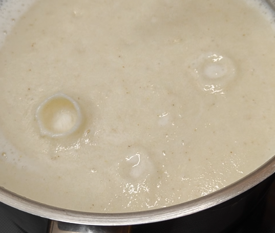 Bulles de dégazage en forme de cratère dans de la semoule en cuisson
